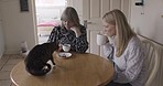 Cat, mother and daughter drink coffee in morning to relax, have conversation and discussion for bonding, together and chat. Feline pet, girl visit mama and enjoy hot beverage for talking or speaking 