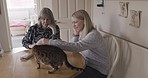Family, cat and home visit with senior woman and daughter talking, happy and spending quality time with their pet. Happy women friend having conversation about love, lifestyle and care in a house