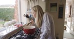 Woman, cooking and smelling food in pot on gas stove for a healthy meal for dinner in home kitchen for health and wellness. Housewife, chef or female making soup for nutrition, eating and supper 
