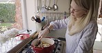 Cooking, food and kitchen with a woman in her home, preparing a meal on a gas stove in a pot or pan. Chef, cook and health with a lady making lunch or dinner in a house for diet or health eating