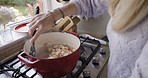Kitchen, food and cooking with a woman in her home, preparing a meal on a gas stove for lunch or dinner. Vegetables, nutrition and eating with a female stirring ingredients in a pan in her house