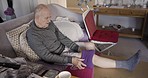Senior man, leg or surgery rehabilitation in nursing home or house and warm bean bag in pain relief, injury management or swelling. Retirement elderly, knee pain on sofa and heating with time