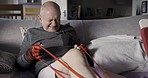 Stretching, physiotherapy and rubber band with old man for rehabilitation, exercise and training. Medical, healthcare and workout with patient on home sofa for retirement, healing and muscle therapy 