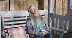 Relax, coffee and woman on a swing chair at her home on the outdoor front porch in Australia. Rest, calm and happy mature lady in retirement enjoying a cup of tea while relaxing outside at her house.