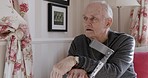 Dementia, disability and senior man speaking with a mental health problem on the sofa of a house. Depression, sad and elderly disabled person talking about a memory during retirement in a home