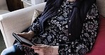 Digital tablet, relax and senior woman sitting on sofa in the living room of her modern house. Calm, technology and elderly lady relaxing while scrolling on social media with mobile device in lounge.