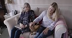 Senior mother, daughter and cat on sofa in home living room together for bonding, care and visit. Elderly lady, animal pet and women in conversation, talking and love in lounge, nursing home or house