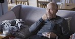 Rehabilitation, pills and senior man on sofa with drink in living room of nursing home or apartment. Medicine, mobility disability in retirement and healthcare, grandpa taking pills for chronic pain.