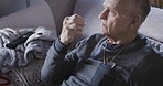 Senior man drink medicine pills with a glass of milk or supplement capsule on sofa in home. Elderly male in recovery with a pill or medical prescription drug for health, wellness or pain antibiotics
