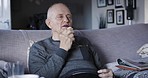 Eating, rehabilitation and retirement with a senior man talking while sitting on a sofa in the living room of his home. Food, nutrition and recovery with a mature male on his lounge couch to relax