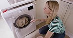 Washing machine, laundry and woman cleaning home with clothes basket for cleaning service, spring cleaning and housework. Housewife, cleaner or maid putting fabric in electrical appliance in house