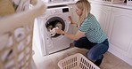 Laundry, washing machine and woman doing housework, clean clothes in house or apartment. Cleaning, washing clothing or bedding and modern housewife busy doing household chores at home in Australia.&nbsp;