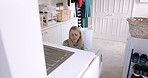 Woman, laundry and clothing in house work for domestic cleaning or home hygiene indoors. Female cleaner taking clothes out of washing machine in routine for cleanliness, sanitary and hygienic wear