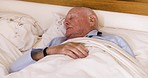 Senior man and sleeping with phone alarm wake up in the morning and tired yawn in bedroom. Elderly, tech and smartphone alarm clock of retirement person in bed waking up for appointment.

