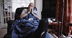 Senior man, sick flu and blowing nose with a tissue, covid and sofa. Elderly male with cold or covid 19, retirement and looking tired, sitting alone at home in the living room with virus or disease