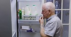 Hungry, decision and senior man at fridge, thinking and diet for health with fruit. Idea, retirement and elderly person with choice at the refrigerator for a food snack with nutrition in the kitchen