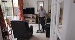 Senior man, cleaning and vacuum in living room, home or floor for cleanliness, dust or hygiene. Elderly cleaner, lounge and electrical appliance for spring clean, furniture or sofa at house in London