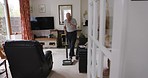 Senior man, vacuum and cleaning his carpet at home for hygiene and housework or housekeeping. Apartment, mature or elderly retired male clean his dirty floor with a machine for domestic chore