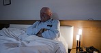 Elderly man with stomach pain, cancer or indigestion relaxing in bed to rest or sleep at home. Sick, ill and senior guy in retirement lying in bedroom with a bowel, abdomen or intestine infection. 