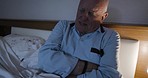 Sick, stomach pain and senior man in bed with a problem in the liver or pancreas at night. Insomnia, sad and frustrated elderly man with medical pain, emergency and body fail in the dark bedroom