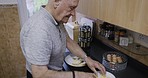 Senior man, breakfast and bread with lunch, cheese and eat in home kitchen, retirement and relax alone on weekend. Food, sandwich and elderly male, meal and prepare snack in the morning in house