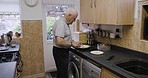 Breakfast, bread and senior man in kitchen making delicious sandwich, apply butter and cutting toast. Food, wellness and nutrition of retired elderly male from Australia with healthy morning meal.