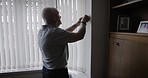 Senior man, window and blinds to spy in home for morning sunshine, open curtain shades and start day in bedroom. Elderly person, curtains and curious homeowner working on shutters in nuring home