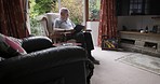 Reading, relax and senior man in nursing home sitting on armchair with book, novel and literature. Rehabilitation, wellness and elderly man enjoy retirement, freedom and leisure time in living room
