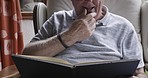 Book, reading and relax with a senior man in his retirement home to relax in the morning with his favorite hobby. Study, sofa and books with a mature male pensioner enjoying a novel in his house