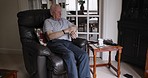 Senior man, check time and thinking in a nursing retirement home relax on a chair. Elderly person sitting in a house waiting on a couch calm about peaceful lifestyle and lounge sofa thoughtful 