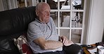 Senior, sad and man with watch time unhappy, disappointed and lonely waiting at retirement home. Depression, thinking and elderly person on pension watching tv with frustrated look on sofa.

