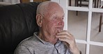 Mental health, retirement and lonely old man thinking,  serious and sitting on sofa in nursing home. Sad, alone and worried senior man with nostalgic memories and feeling grief or loss in living room