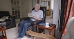 Breakfast, coffee and senior man eating in home living room alone after rehabilitation session. Health, nutrition and retired elderly male from Canada having food, drinking tea and relaxing in house.