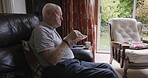 Food, eating and sandwich with a senior man biting into bread while sitting in his home living room. Health, diet and hungry with a mature male pensioner enjoying a snack in his house alone