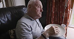 Food, eating and time with a senior man watching tv while enjoying a sandwich in his retirement home. Bread, television and relax with a mature male pensioner sitting in the living room of a house