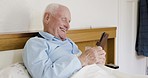 Senior man, laughing and phone in bedroom for comic internet news, social media meme and online crossword game. Smile, happy and relax retirement elderly on mobile technology in house or nursing home