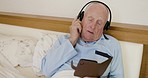 Senior man, headphone and phone with singing, music and listening while streaming, relax and bed in morning. Elderly male enjoy audio app on mobile smartphone, sing and technology in home bedroom
