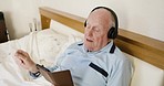 Music, old man in bed with phone and headphones singing along with smile and happiness. Streaming service, technology in retirement and happy senior man listening to nostalgic online radio in bedroom