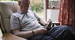 Old man, phone and browsing with wifi online for internet news while relaxing in his retirement home. Social media, smartphone and elderly retired male texting a digital contact for communication  