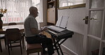 Senior man, playing or piano learning in house or nursing home living room and composition music sheet, sound notes or relax jazz. Pianist, musician or retirement elderly on audio instrument keyboard