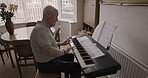 Music, home and old man play piano, having fun and enjoying time alone. Musical instrument, retirement and elderly male from Canada on electric or digital keyboard playing a song in house living room