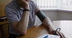 Senior man, blood pressure and self care in home for healthcare, wellness and waiting with anxiety. Elderly patient, sick and medical machine for test, results or healthy body in retirement in house