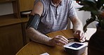 Elderly man, checking blood pressure and heart rate with monitor or machine in healthcare at home. Senior male monitoring cardiovascular rate for heart diagnostic test or BPM on table at the house