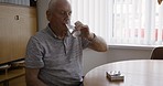 Medicine, pills and senior man drinking water in home for health and wellness in the morning. Vitamins, supplements and retired elderly male from Australia taking tablets for pain, illness or disease