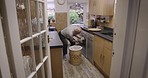 Senior man, dirty laundry and washing machine in kitchen, home and cleaning alone with technology for hygiene. Elderly gentleman, washing clothes and clean in apartment, house or flat for cleanliness