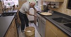 Elderly man, washing machine and doing laundry in kitchen with washing basket for cleaning clothing, fabric and garments. Domestic life, housekeeping and using electrical appliance for fresh clothes 