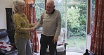 Disability, senior couple and help with walking, balance and support in their home together. Love, trust and elderly woman helping man in a wheelchair, standing and holding hands while bonding