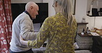 Support, love and disability with a senior couple in the living room of their home together for help or assistance. Trust, care and walking stick with a mature wife helping her husband in the house