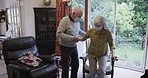 Senior care, husband helping wife walk and support in rehabilitation with walking stick. Couple in retirement home together, assistance with standing up and elderly woman with face mask indoors
