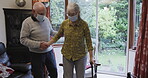 Covid, disability and senior couple in retirement home with walking stick support, hand holding together. Elderly people or disabled woman with partner helping in living room with cane for Parkinson